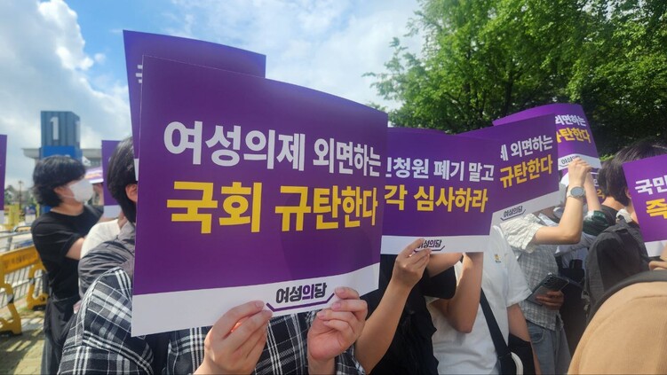 여성의당이 15일 오후 서울 여의도 국회 앞에서 연 ‘국민청원 심사 무기한 연장 결정 규탄 기자회견’ 참가자들이 손푯말을 들고 있다. 장종우 기자