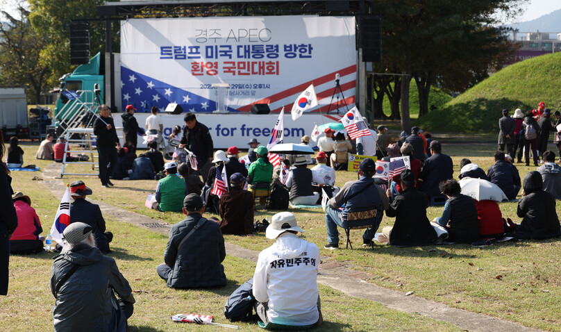 29일 오후 경북 경주시 내남네거리 인근에서 열린 ‘트럼프 미국 대통령 방한 환영 국민대회’에서 참가자들이 앉아 있다. 최현수 기자 emd@hani.co.kr