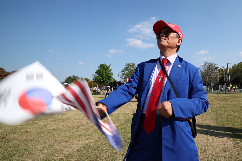 29일 오후 경북 경주시 내남네거리 주변에서 열린 ‘트럼프 미국 대통령 방한 환영 국민대회’에서 한 참가자가 태극기와 성조기를 흔들고 있다. 최현수 기자 emd@hani.co.kr