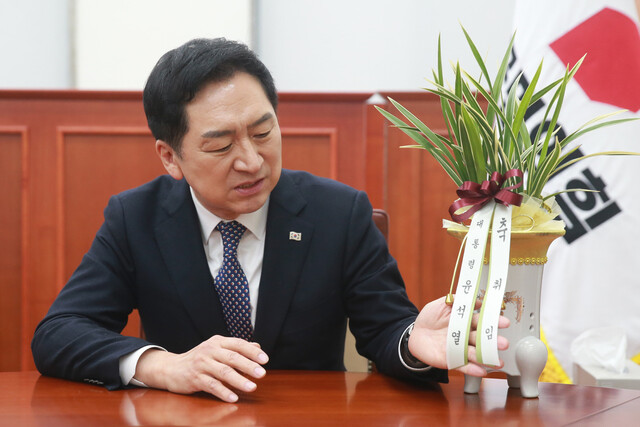 김기현 국민의힘 의원(당시 신임 당대표)가 2023년 3월9일 오전 국회에서 이진복 대통령실 정무수석에게 전달받은 윤석열 대통령의 축하난을 바라보고 있다. 공동취재사진