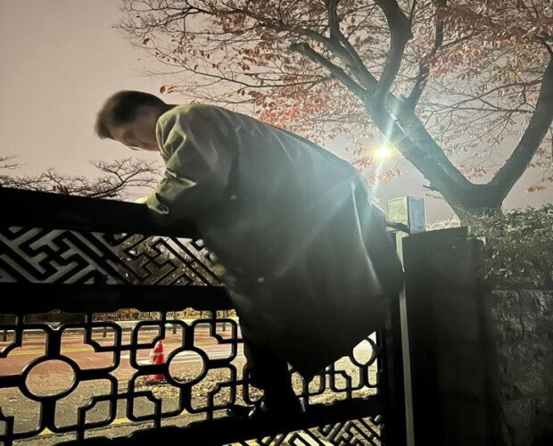 윤석열 전 대통령이 비상계엄을 선포한 지난해 12월3일 밤 11시께, 경찰이 통제 중인 서울 여의도 국회에서 우원식 국회의장이 담을 넘어 본청으로 향하고 있다. 국회의장실 제공