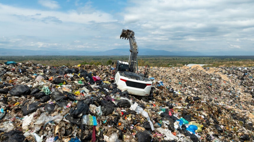 굴착기 한 대가 생활 쓰레기가 뒤덮인 쓰레기 매립지에서 굴착 작업을 하고 있다.게티이미지뱅크