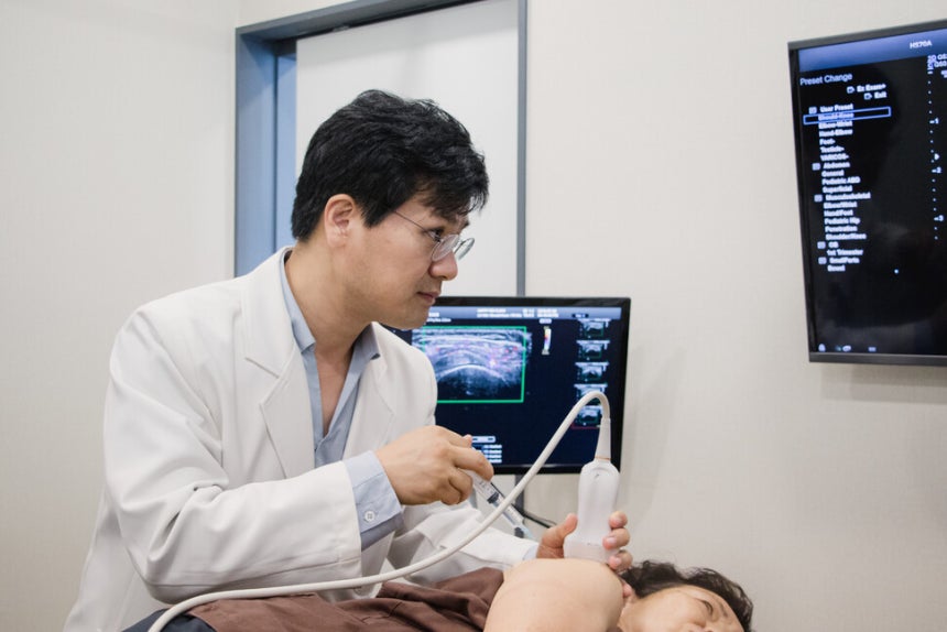 김정훈 원장이 환자에게 초음파 시술을 하고 있다.