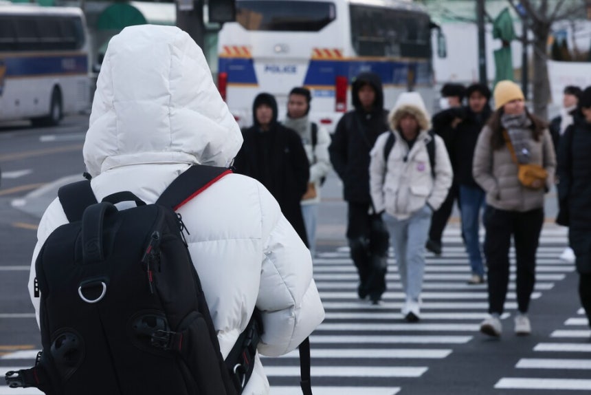 기온이 영하권으로 떨어지며 추운 날씨를 보인 25일 서울 종로구 광화문광장에서 외투 모자를 쓴 시민과 관광객들이 길을 건너고 있다.연합뉴스 