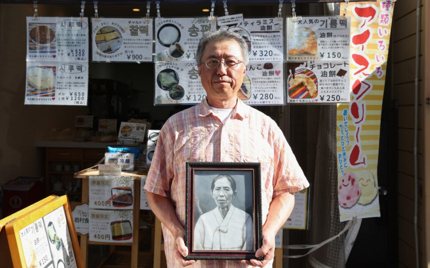 홍성민씨가 지난 7월 27일 오후 일본 오사카 코리아타운 이와무라 식품에서 할머니 김양능씨의 영정을 들고 사진을 찍고 있다.이와무라 식품은 홍성민씨가 할머니 고 김양능씨에게 조리법을 전수 받아 전통 제주식 떡을 판