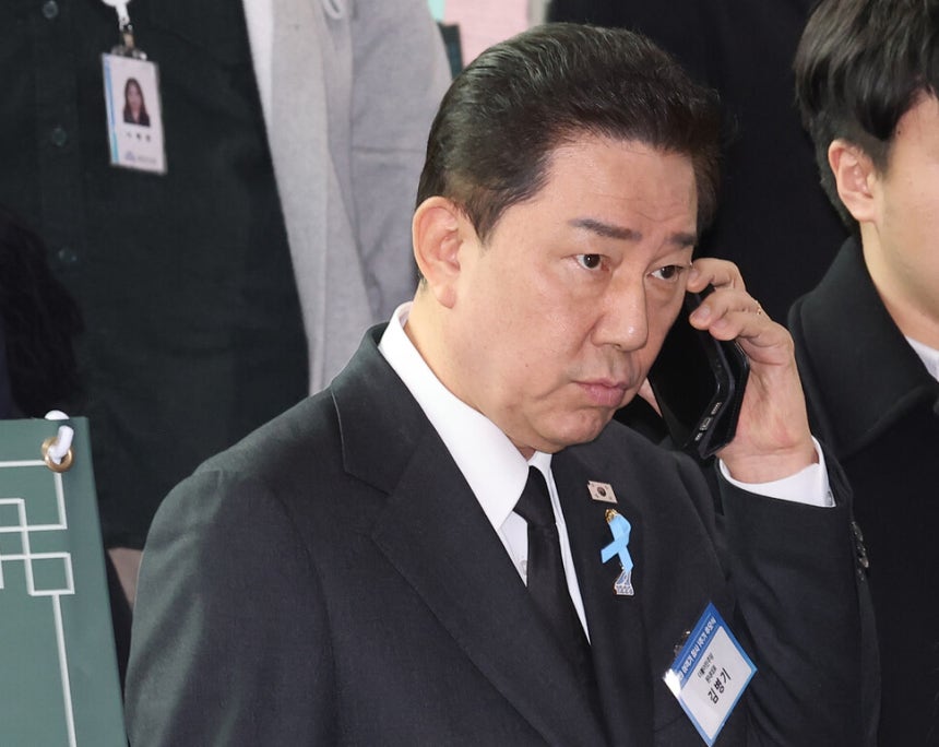 더불어민주당 김병기 원내대표가 29일 전라남도 무안군 무안국제공항 여객터미널에서 열린 12ㆍ29 여객기 참사 1주기 추모식을 마친 뒤 이동하며 전화 통화를 하고 있다.연합뉴스