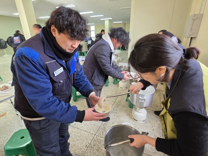 한국지엠 세종부품물류센터 해고 노동자 최현욱(36)씨가 1일‘집단해고 철회’를 촉구하는 점거 농성장에서 새해맞이 떡만둣국을 배식받고 있다.최예린 기자