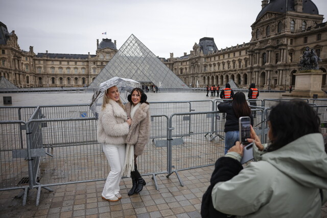 여행객들이 12일 프랑스 파리 루브르 박물관 안뜰의 유리 피라미드 조형물 앞에서 기념사진을 찍고 있다.EPA 연합뉴스