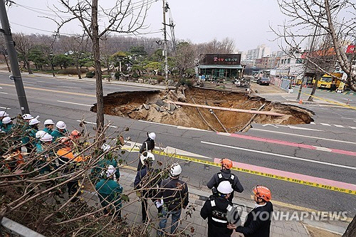 지난 3월 25일 서울 강동구 대명초등학교 도로에서 전날 발생한 대형 땅꺼짐 현장의 모습.전날 오후 명일동 대명초등학교 인근 사거리에서 발생한 지름 20ｍ,깊이 18ｍ가량의 대형 싱크홀(땅꺼짐)에 오토바이 운전자
