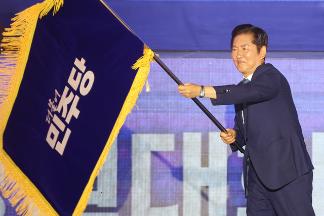 정청래 더불어민주당 신임 당대표가 지난 8월2일 경기 고양 킨텍스에서 열린 전국당원대회에서 최종 선출된 뒤 당기를 흔들어 보이고 있다.<연합뉴스 사진>