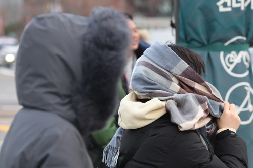 서울 아침 기온이 영하 7도까지 내려가며 강추위가 찾아온 3일 서울 종로구 광화문네거리에서 한 시민이 목도리를 얼굴에 두르고 있다.[연합뉴스]