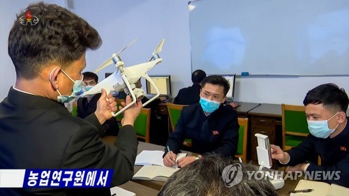 중국 DJI 팬텀4 드론 살펴보는 북한 농업연구원(조선중앙TV=연합뉴스)