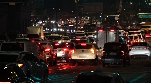 올겨울 많은 양의 첫눈이 내린 지난 4일 서울 종로구 경복궁역 인근에서 차량이 빙판길에 정체를 빚고 있다.[연합뉴스]