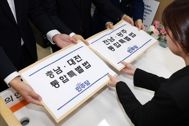 더불어민주당 천준호 원내운영수석부대표(가운데), 전용기 원내소통수석부대표(왼쪽), 백승아 원내대변인이 지난달 30일 국회 의안과에 충남대전통합특별법안과 전남광주통합특별법안을 제출하고 있다. [연합뉴스]