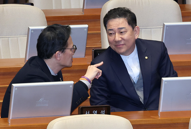 더불어민주당 원내대표직 사퇴 후 탈당한 무소속 김병기(오른쪽) 의원과 박주민 민주당 의원이 지난 2월 10일 국회 본회의장에서 열린 경제분야 대정부질문 도중 대화하고 있다.[연합뉴스 사진]
