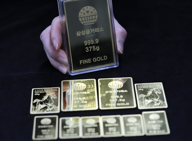 서울 종로구 삼성금거래소에서 직원이 골드바를 들어보이고 있다. [연합뉴스]