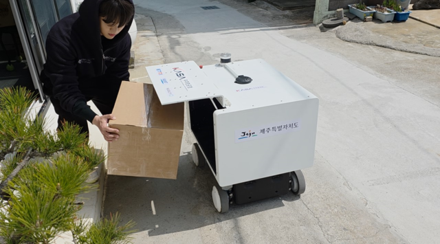 제주 금능포구에서 비양도로 드론을 이용해 가져온 물품을 로봇이 배달해 문 앞에 배송하는 모습.우주청 제공.