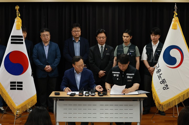 지난 20일 경기도 수원시 장안구 경기고용노동청에서 열린 삼성전자 임금협상을 마친 후 여명구 삼성전자 DS 피플팀장과 최승호 삼성그룹 초기업노동조합 삼성전자지부 위원장이 잠정 합의안에 서명하고 있다. [사진공동취재