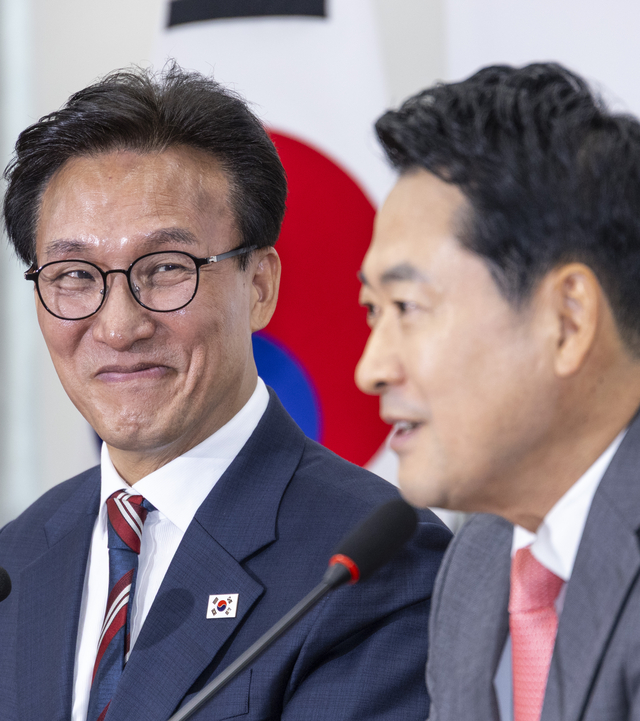 김민석(왼쪽) 더불어민주당 당대표가 지난 8월 24일 국회에서 취임 인사차 장동혁(오른쪽) 국민의힘 대표를 예방한 자리에서 인사말을 듣다 미소짓고 있다. [연합뉴스]