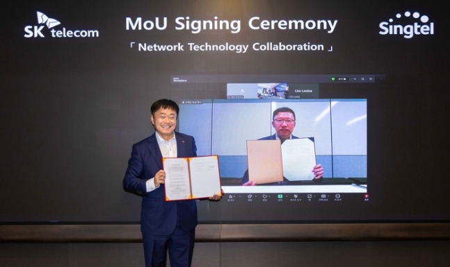Kang Jong-ryul, SKT ICT Infra Department Manager (left) and Teay You Ryan, Singtel Network Department Managing Director, taking a commemorative photo at the MOU signing ceremony