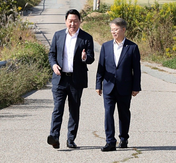 최태원 SK그룹 회장(왼쪽)이 9일 광주 탄약고 부지를 방문해 민형배 전남광주통합특별시장(오른쪽)과 함께 현장을 둘러보며 대화를 나누고 있다.