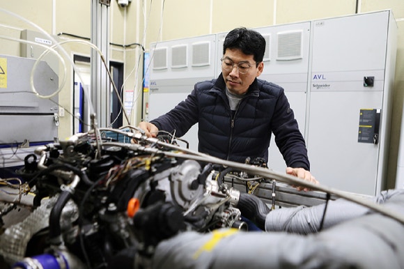 Principal Researcher Park Chul-woong of the Eco-friendly Mobility Research Department at the Korea Institute of Machinery & Materials examines the ammonia engine. [Photo: KIMM]
