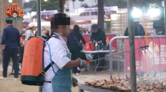 한 직원이 지역축제 현장에서 농약통에 든 사과주스를 음식에 뿌리고 있는 모습.[사진=백종원 유튜브 캡처]