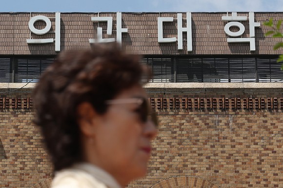 지난 7일 오전 한 시민이 서울 시내 한 의과대학 앞을 지나가고 있다.[사진=연합뉴스]