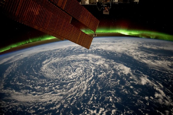지구 상공 420km 국제우주정거장에서 본 지구.구름이 알래스카만 위로 소용돌이치고,오로라 아래에서 지구 지평선을 덮고 있는 모습이다.[사진=NASA]