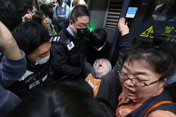 박경석 전국장애인차별철폐연대(전장연) 대표가 지난해 4월 21일 서울 지하철 4호선 혜화역에서 제62차 '출근길 지하철 탑니다' 시위를 벌이던 중 이를 저지하던 서울교통공사 관계자와 충돌하고 있다.[사진=연합뉴스]