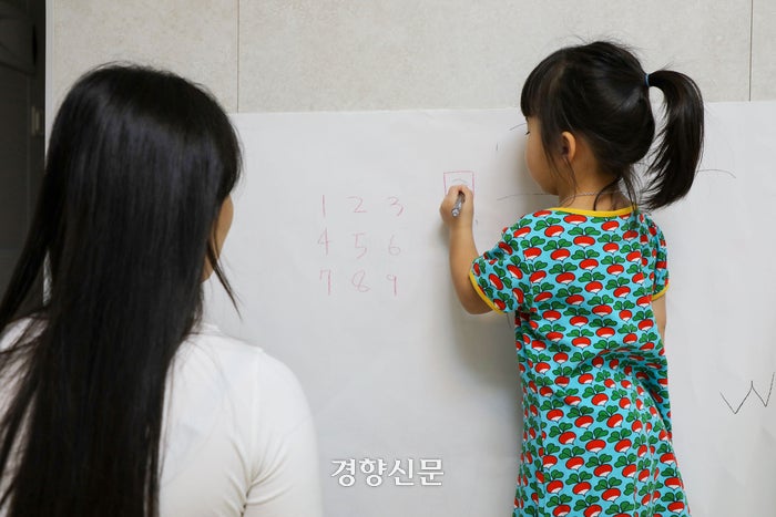 지난 12일 서연(가명·21)이 집 거실에 전지를 붙여놓고 은지(가명·3)와 숫자 공부를 하고 있다. 한수빈 기자