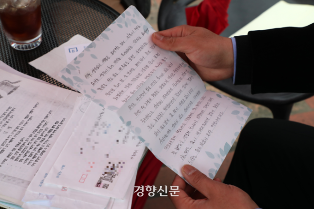 장모씨가 지난 3일 경기 분당의 한 카페에서 경향신문과 인터뷰하며 구치소에서 동생에게 보낸 편지를 보여주고 있다. 정지윤 선임기자