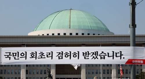 12일 오후 서울 여의도 국회의사당 앞에서 국민의힘이 설치한 현수막이 걸려있다. 연합뉴스