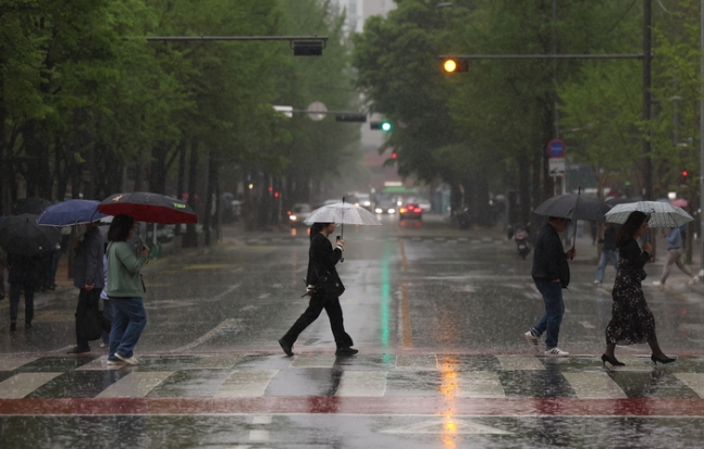 비가 내린 지난 15일 오전 서울 영등포구 여의도역 인근에서 시민들이 우산을 쓰고 이동하고 있다. 연합뉴스