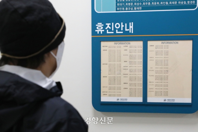 의대 교수들이 사직서를 제출한 지 한 달이 되어가는 24일 교수진이 주 1회 휴진을 결정한 서울의 한 대형병원에서 한 내원객이 휴진 안내문을 살펴보고 있다. 한한수빈 기자