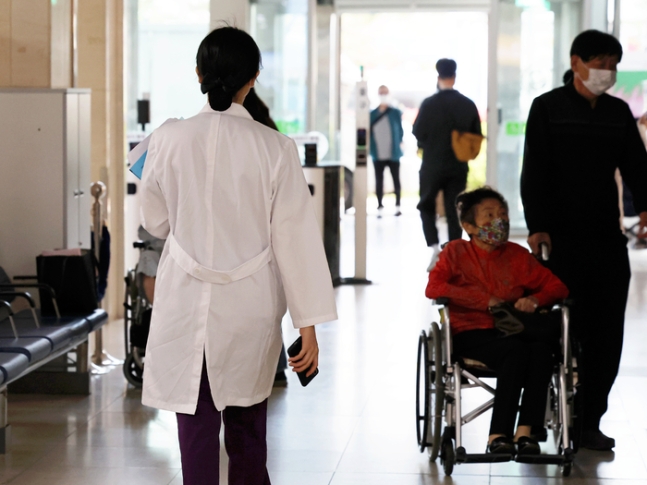 의정 갈등이 이어지고 있는 26일 광주 동구 전남대병원에서 의료진이 이동하고 있다. 전남대 의과대학 교수 비대위는 주 1회 휴진을 결정했다. 연합뉴스