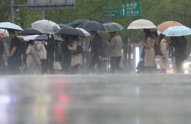 서울 광화문광장에서 시민들이 우산을 쓴 채 걸어가고 있다. 연합뉴스.