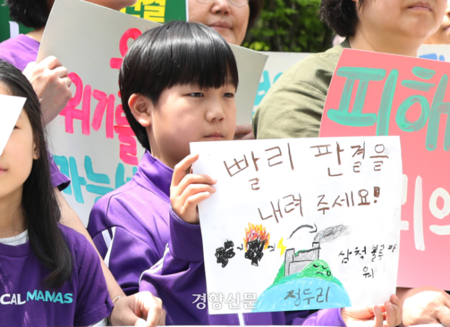 정두리양(9)이 이른바 ‘기후소송’의 헌법재판소 공개변론날이었던 지난달 23일 서울 종로구 헌법재판소 앞 기자회견에서 손팻말을 들고 있다.  정효진 기자