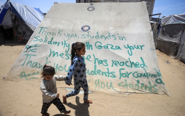가자지구 최남단 라파의 피란민 캠프에서 어린이들이 반전 시위를 벌이는 미국 컬럼비아대학 학생들에게 고마움을 전하는 문구가 쓰인 텐트를 지나고 있다. UPI연합뉴스