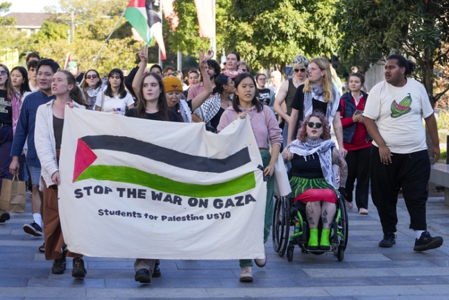호주 시드니에서 24일 팔레스타인을 지지하는 시위대가 ‘가자지구 전쟁을 멈춰라’라고 쓴 현수막을 들고 행진하고 있다.  AP연합뉴스