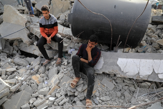 가자지구 라파에서 21일 팔레스타인 주민들이 이스라엘의 공습으로 폐허가 된 거리에 앉아있다.  신화연합뉴스