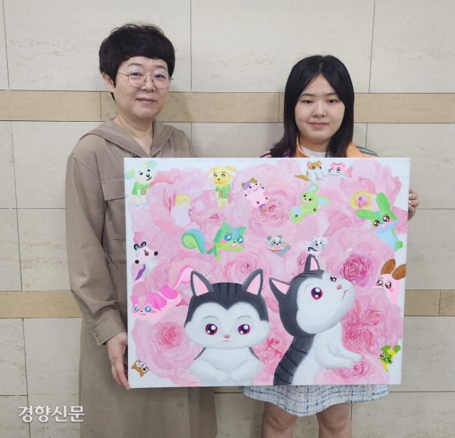 한남대 회화과 학생 김지우씨(오른쪽)와 어머니인 신여명씨가 김씨의 작품을 들고 기념촬영을 하고 있다.