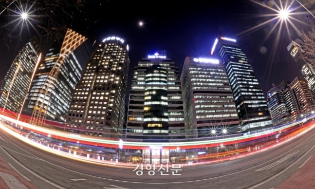 서울 여의도 환승센터 주변 불이 켜진 증권회사 건물 주변 도도를 차량들이 지나고 있다./홍도은 기자 hongdo@kyunghyang.com
