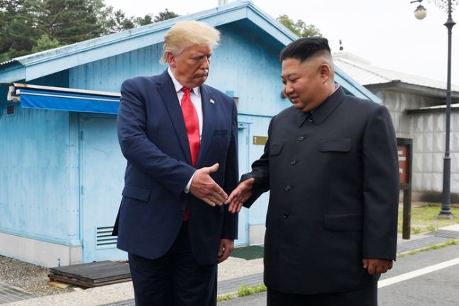 도널드 트럼프 전 미국 대통령(왼쪽)과 김정은 북한 국무위원장이 2019년 6월30일 판문점 앞뜰에서 악수를 하고 있다.   AP연합뉴스