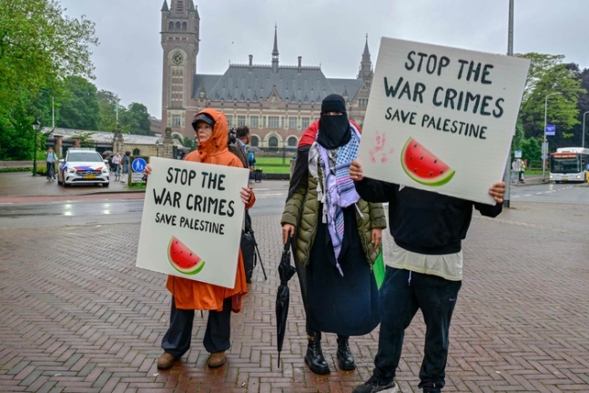 팔레스타인 지지 시위대가 지난 24일(현지시간) 네덜란드 헤이그 국제사법재판소(ICJ) 앞에서 이스라엘의 가자지구 공격 중단을 촉구하고 있다. 수박은 팔레스타인 국기에 담긴 빨간색, 녹색, 검은색, 흰색이 모두 포함