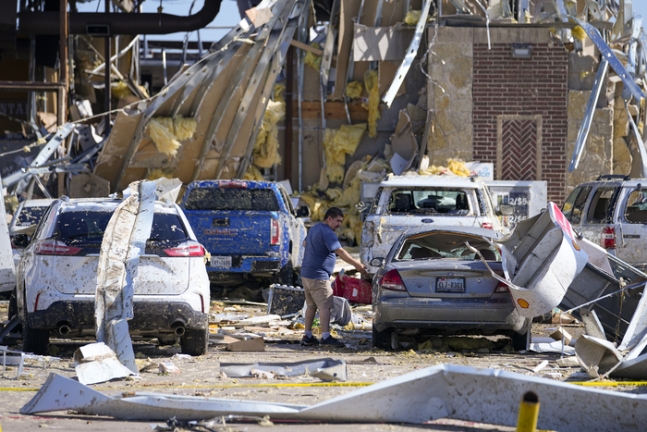 26일(현지시간) 텍사스 밸리뷰에서 한 남성이 토네이도가 강타해 피해를 입은 자동차를 바라보고 있다. AP연합뉴스
