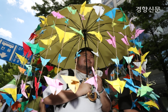 제25회 서울퀴어문화축제가 열린 1일 서울 중구 을지로 일대에서 참가자 감자곰씨가 직접 만든 우산을 쓰고 있다.