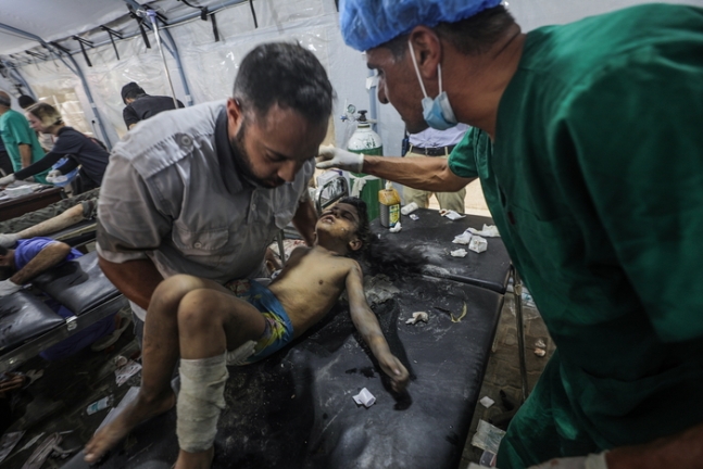 8일(현지시간) 팔레스타인 의료진이 이스라엘군의 인질 구출 작전으로 누세라이트 난민촌에서 부상을 입은 아이를 인근 알아우다 병원으로 옮기고 있다. EPA연합뉴스