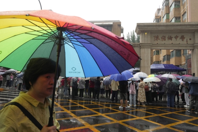 가오카오 첫 날인 지난 7일 베이징의 한 시험장 교문에서 우산을 든 학부모가 자녀를 기다리고 있다./AP연합뉴스