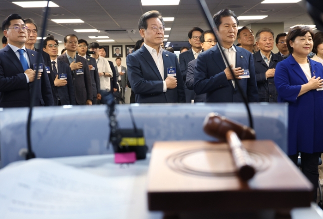 이재명 더불어민주당 대표가 지난 6월 17일 여의도 당사에서 열린 중앙위원회에서 국기를 향해 경례하고 있다. 연합뉴스